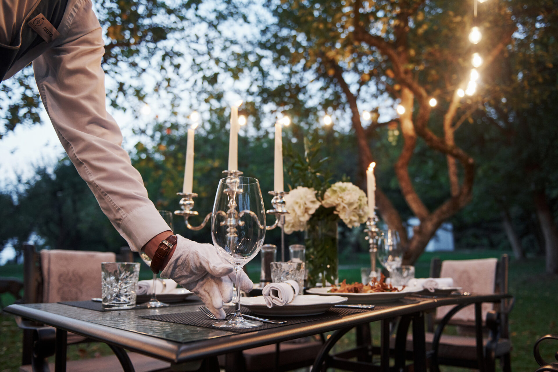 Candlelit dinner setup overlooking vineyard rows for experiential dining