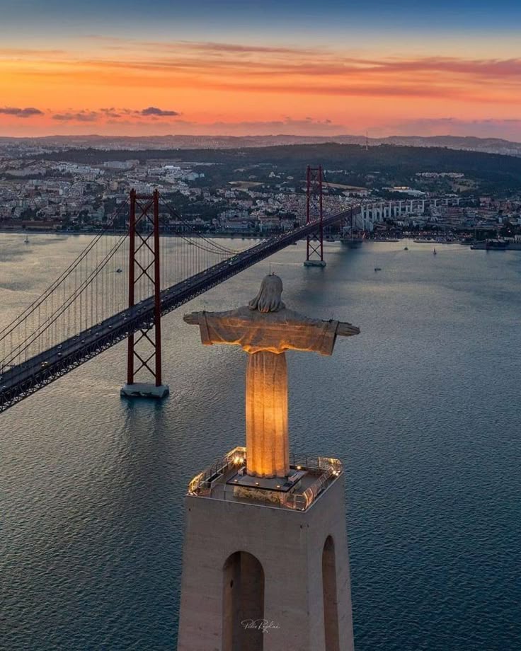 Panorama aérien de Lisbonne avec le pont du 25-Avril et la statue du Cristo Rei au coucher du soleil, illustrant la position stratégique de la ville et son attractivité pour l’investissement immobilier.